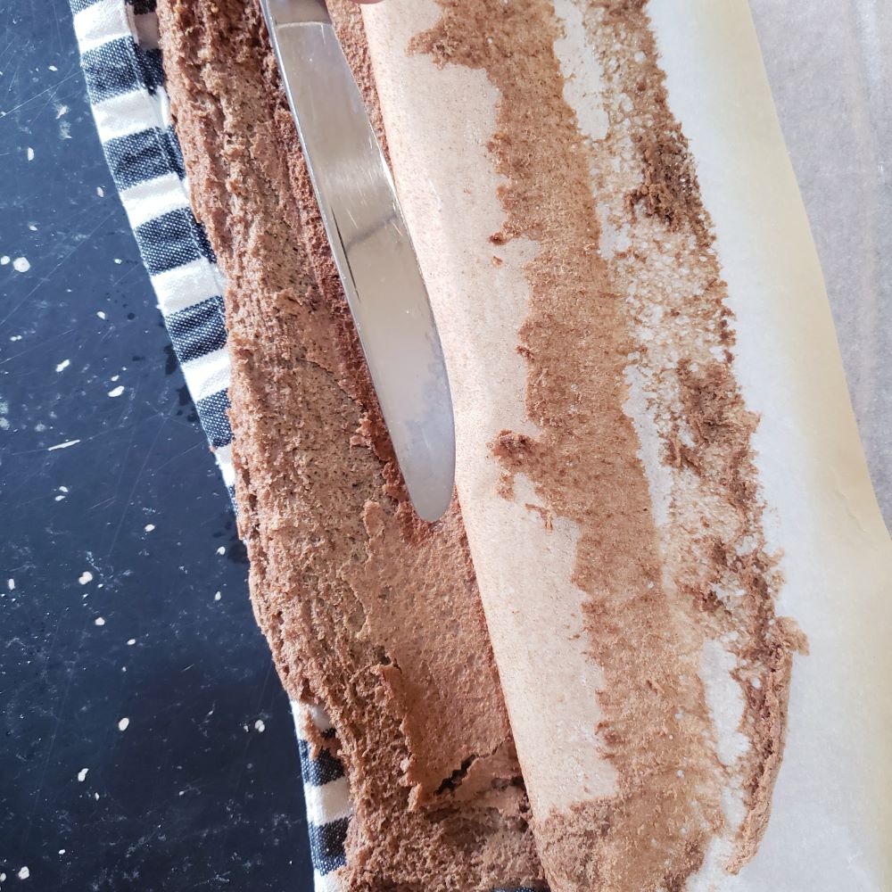 Peeling parchment paper from cake Removing parchment paper from cake.