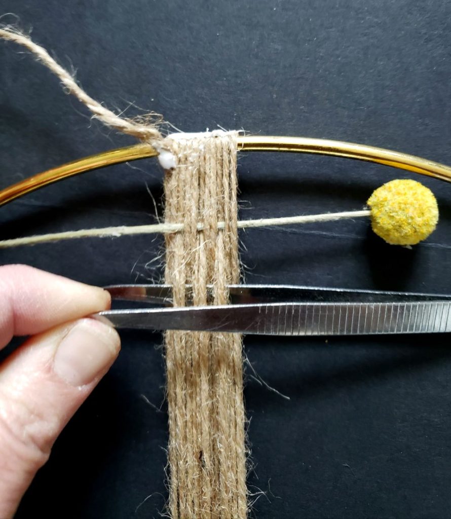 Weaving a dried flower wreath using tweezers