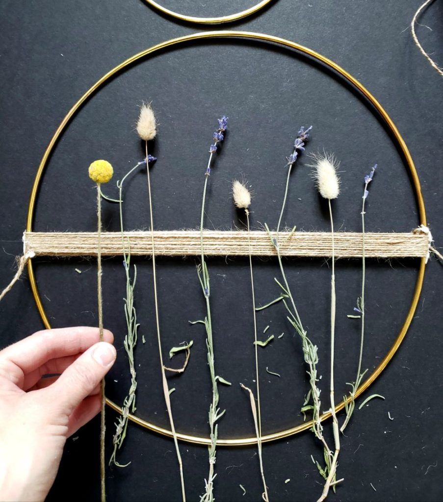 Placement of dried flowers on wreath