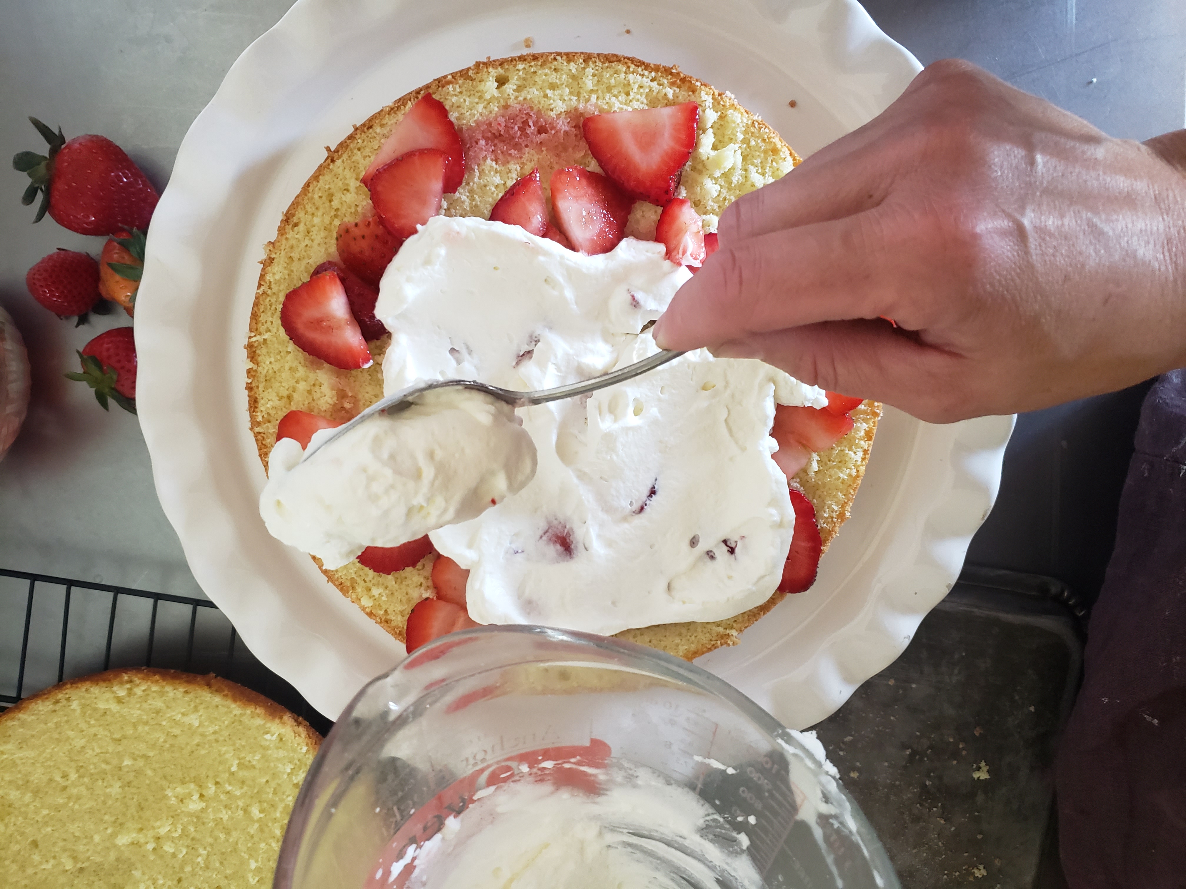 Adding whipped cream to a cake layer