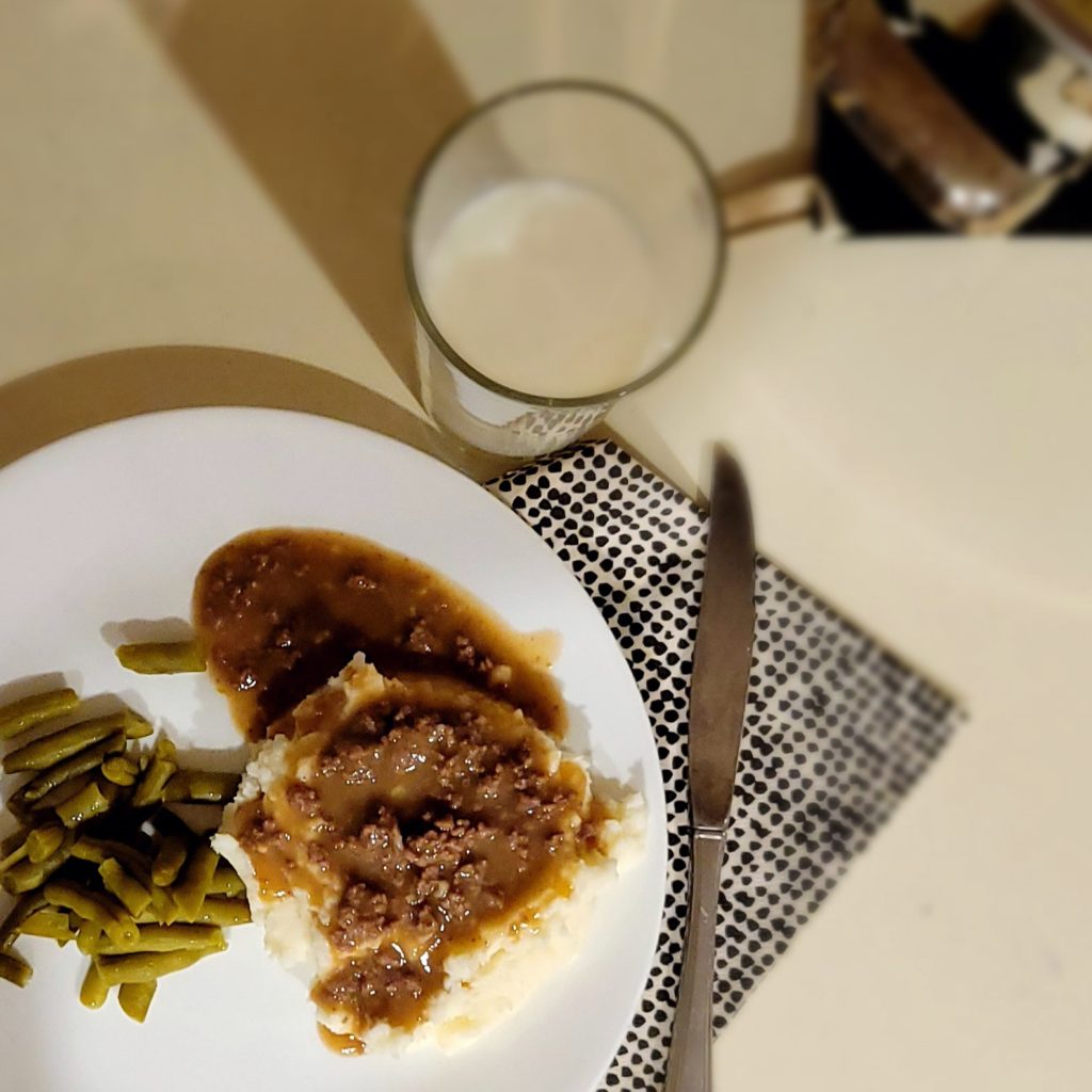 Meat gravy and mashed potatoes on a white plate