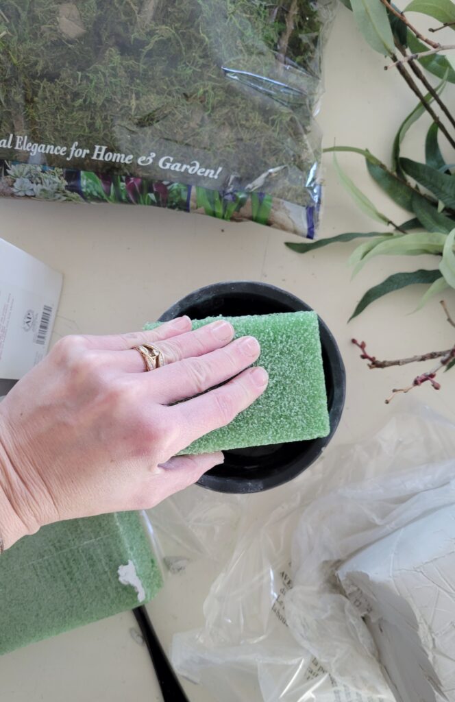Pressing floral foam into pot